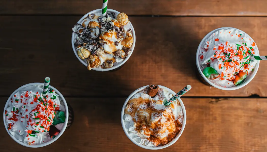 Quatre chocolats chauds garnis de crème fouettée et de pépites festives servis à la ferme d'arbres de Noël de Snyders.