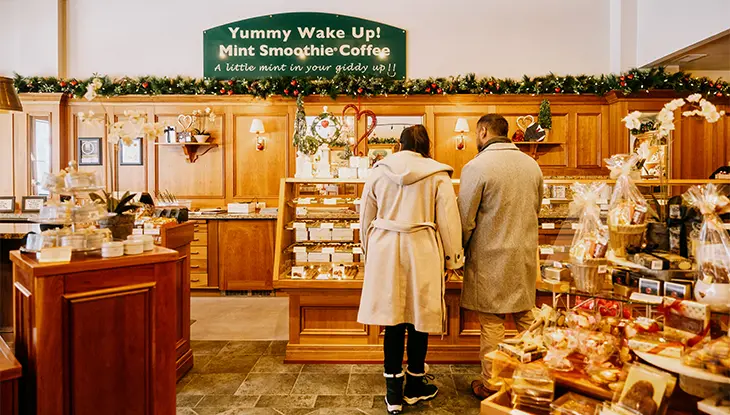 Couple regardant les chocolats à l’intérieur d’une confiserie traditionnelle.