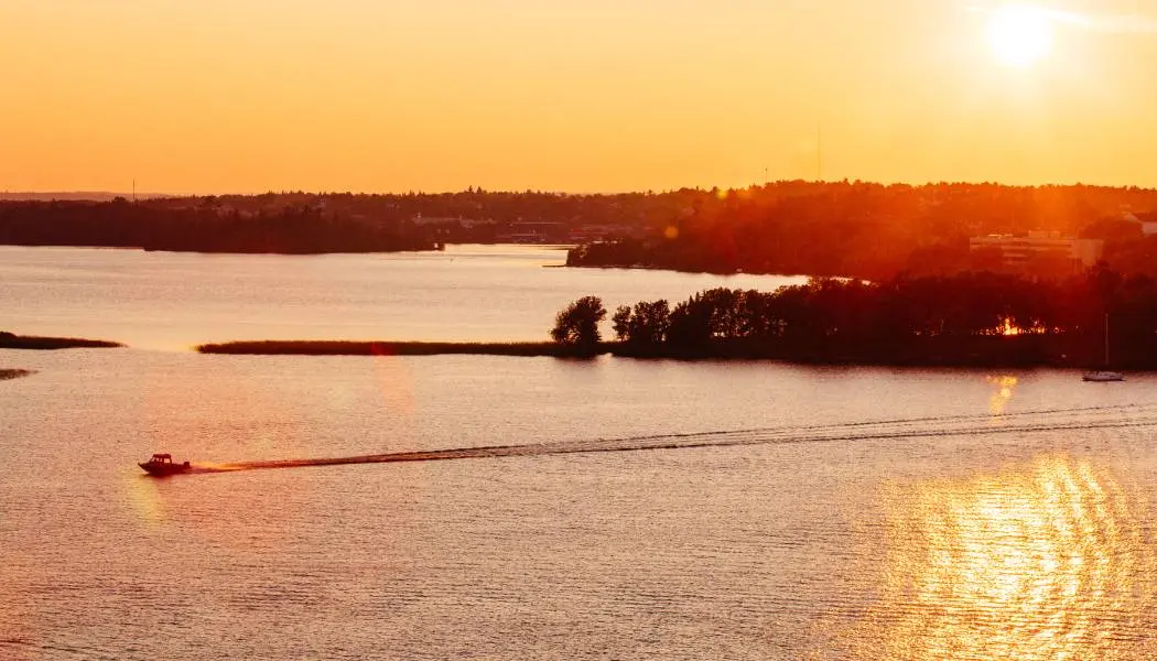 Sunset over Northern Ontario's Lake of the Woods paints the sky and lake bright orange.