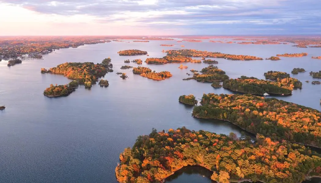 Vue aérienne des Mille-Îles illuminées par les couleurs automnales qui parsèment le fleuve Saint-Laurent.
