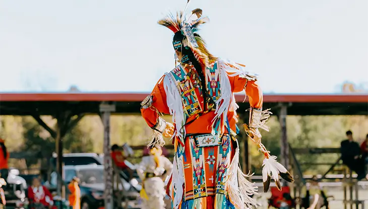 Personne autochtone en costume colorée dansant pendant un pow-wow au parc Thunderbird.