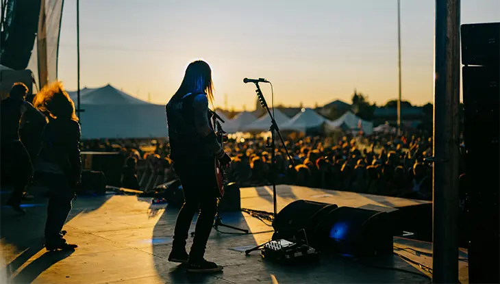 夏の音楽祭で、夕暮れ時の野外コンサートステージで演奏するミュージシャンたち。