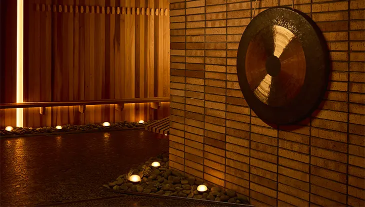 Patio de spa tranquilo con iluminación cálida, agua poco profunda y una pared circular.