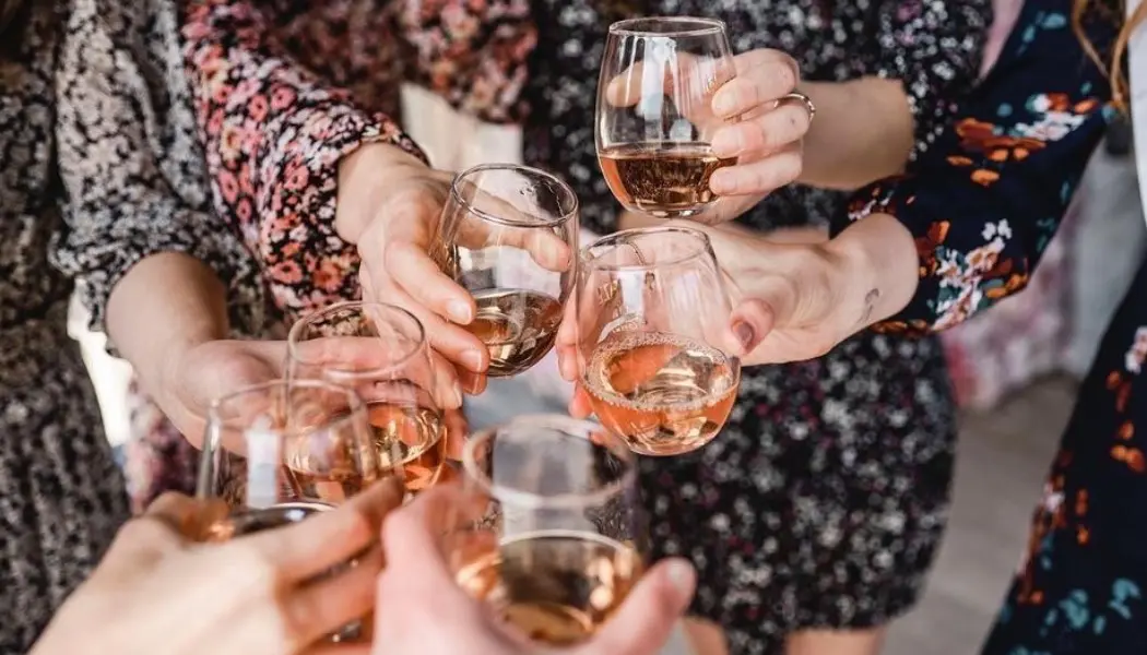 A group of women raises their glasses in a toast while wine tasting at Trius Winery.
